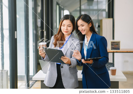 Asian business colleague business presents and explains and using laptop and tablet. Teamwork, financial marketing team, 133511805