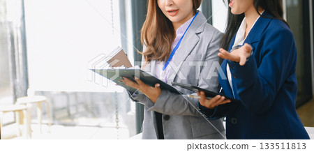 Asian business colleague business presents and explains and using laptop and tablet. Teamwork, financial marketing team, Asian business colleague business presents and explains and using laptop and tablet. Teamwork, financial marketing team, 133511813