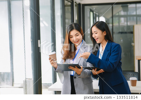 Asian business colleague business presents and explains and using laptop and tablet. Teamwork, financial marketing team, Asian business colleague business presents and explains and using laptop and tablet. Teamwork, financial marketing team, 133511814
