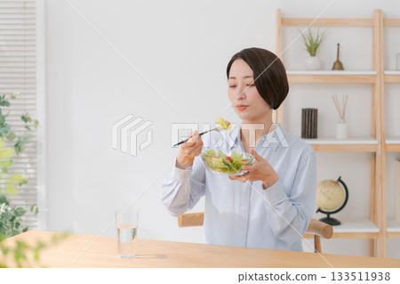 一位三十多歲的女性正在吃沙拉 一位三十多歲的女性正在吃沙拉 133511938