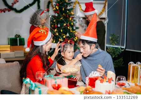Joyful Asian family celebrating Christmas together with gifts, festive food, and decorations, capturing love, Joyful Asian family celebrating Christmas together with gifts, festive food, and decorations, capturing love, 133512269