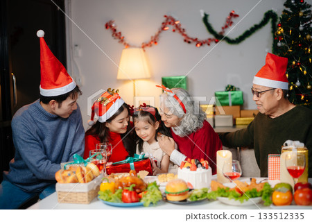 Joyful Asian family celebrating Christmas together with gifts, festive food, and decorations, capturing love, Joyful Asian family celebrating Christmas together with gifts, festive food, and decorations, capturing love, 133512335
