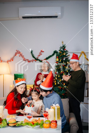 Joyful Asian family gathered for a Christmas feast, exchanging gifts, and celebrating the holiday season with love 133512337