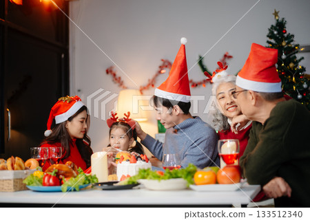 Joyful Asian family celebrating Christmas together with gifts, festive food, and decorations, capturing love, 133512340