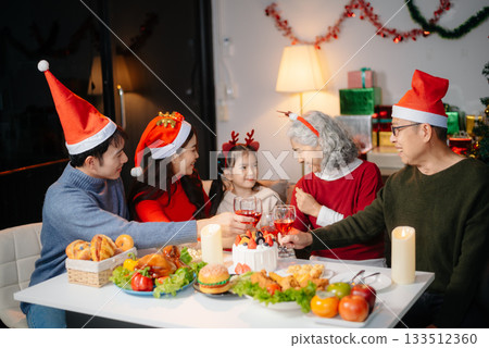 Joyful Asian family gathered for a Christmas feast, exchanging gifts, and celebrating the holiday season with love Joyful Asian family gathered for a Christmas feast, exchanging gifts, and celebrating the holiday season with love 133512360