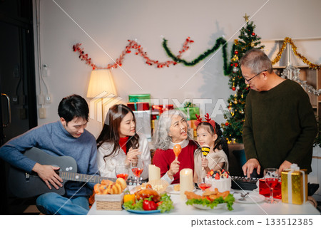 Celebrate Christmas with family in a cozy, festive setting filled with gifts, love, and joy. 133512385