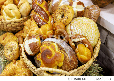 Artisan breads in different shapes are arranged in decorative baskets at local bakery. Artisan breads in different shapes are arranged in decorative baskets at local bakery. 133512405