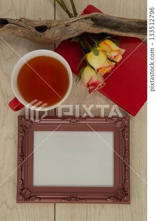 Photo frame, lemon tea, diary and flowers on wooden table Photo frame, lemon tea, diary and flowers on wooden table 133512796