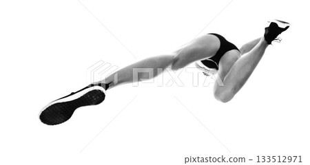 Low angle view of sportswoman long jumping Low angle view of sportswoman long jumping 133512971