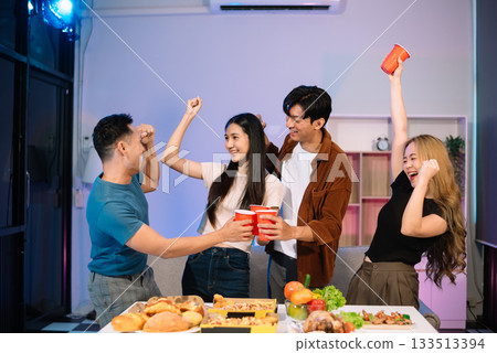 Young Asian Friends Celebrating with Laughter and Food at a Modern Evening Party Young Asian Friends Celebrating with Laughter and Food at a Modern Evening Party 133513394
