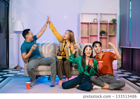 Young Asian Friends Celebrating with Laughter and Food at a Modern Evening Party 133513486