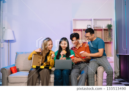 Young Asian Friends Celebrating with Laughter and Food at a Modern Evening Party 133513490