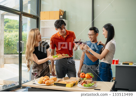 Young Asian Friends Celebrating with Laughter and Food at a Modern Evening Party 133513499