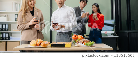 Young Asian Professionals Celebrating with Pizza and Drinks in a Modern Office Setting 133513505
