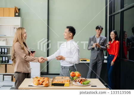 Young Asian Professionals Celebrating with Pizza and Drinks in a Modern Office Setting 133513506