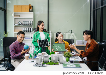 Asian professionals collaborate on sustainable energy solutions with wind turbines, solar panels, and eco friendly models 133513694