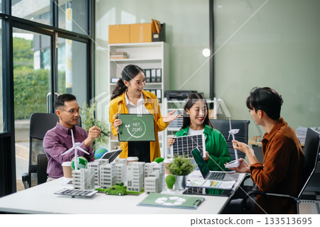 Asian professionals collaborate on sustainable energy solutions with wind turbines, solar panels, and eco friendly models 133513695