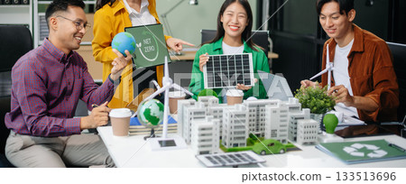 Asian professionals collaborate on sustainable energy solutions with wind turbines, solar panels, and eco friendly models 133513696