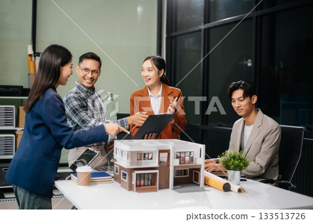 Asian architects and designers brainstorming and collaborating in a modern office, utilizing models and plans Asian architects and designers brainstorming and collaborating in a modern office, utilizing models and plans 133513726
