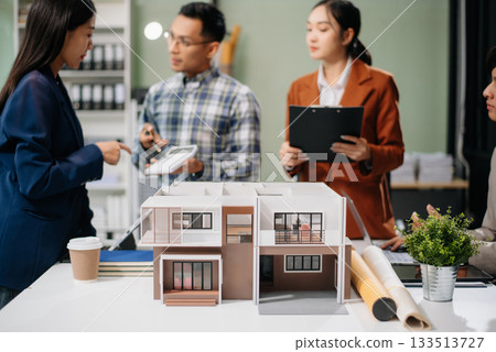 Asian architects and designers brainstorming and collaborating in a modern office, utilizing models and plans Asian architects and designers brainstorming and collaborating in a modern office, utilizing models and plans 133513727
