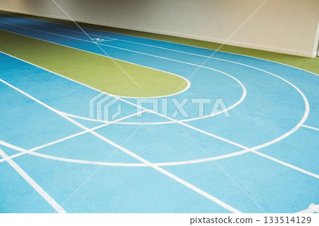 Curved synthetic running track is being shown in flat design, featuring blue lanes with green turf Curved synthetic running track is being shown in flat design, featuring blue lanes with green turf 133514129