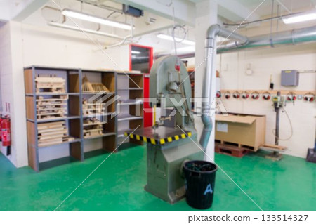 Industrial band saw machine is being shown in flat design workshop, with wooden shelving and hoses 133514327