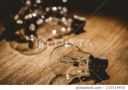 Shiny light bulbs on wooden plank 133514450