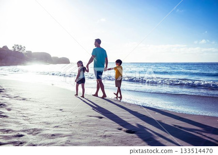 Rear view of caucasian father holding children's hands and walking at beach against sky on sunny day Rear view of caucasian father holding children's hands and walking at beach against sky on sunny day 133514470