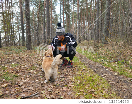 Man Playing with Corgi Dog in Autumn Forest Man Playing with Corgi Dog in Autumn Forest 133514923