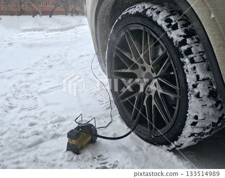 Car Tire Inflation in Snowy Winter Conditions 133514989