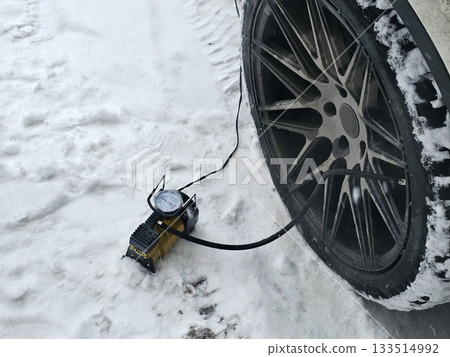 Car Tire Inflation in Snowy Winter Conditions 133514992