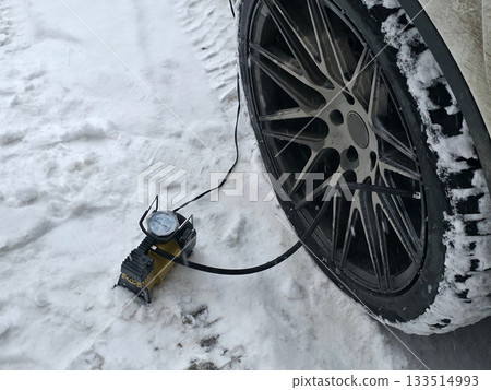 Car Tire Inflation in Snowy Winter Conditions 133514993