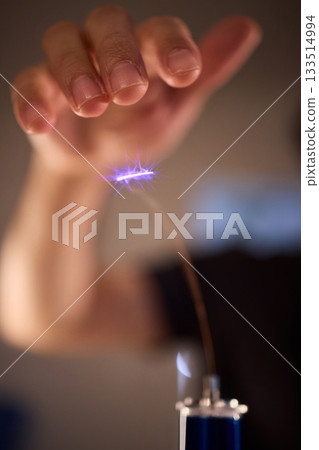 Hands manipulating metal spheres generate vibrant electrical plasma display, Laboratory scene showcasing coil discharging luminous sparks with scientific precision Hands manipulating metal spheres generate vibrant electrical plasma display, Laboratory scene showcasing coil discharging luminous sparks with scientific precision 133514994