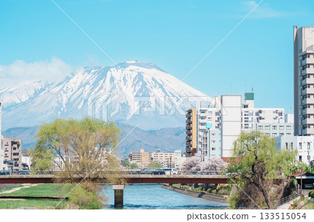 Beautiful Iwate mountain and Kitakami river with flowers blooming in Spring season, cityscape against blue sky in Morioka city, Iwate prefecture, Japan. famous Landmark Travel and Vacation destination Beautiful Iwate mountain and Kitakami river with flowers blooming in Spring season, cityscape against blue sky in Morioka city, Iwate prefecture, Japan. famous Landmark Travel and Vacation destination 133515054