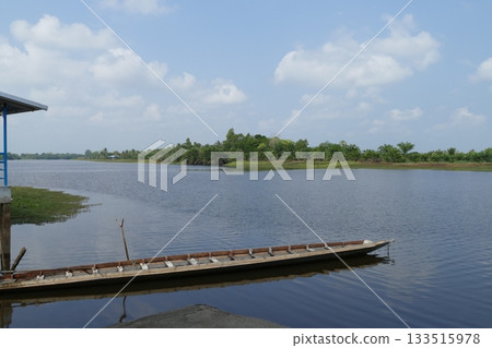 Wooden boat on the river in the nature of thailand and blue sky, view from the pier to the river in summer Wooden boat on the river in the nature of thailand and blue sky, view from the pier to the river in summer 133515978