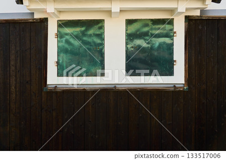 The beautiful contrast between the white and black wooden walls of a traditional Japanese storehouse. The copper windows appear green due to the patina. The beautiful contrast between the white and black wooden walls of a traditional Japanese storehouse. The copper windows appear green due to the patina. 133517006