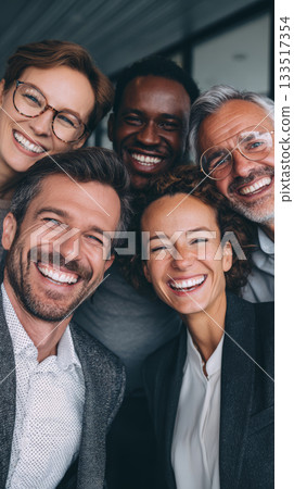 Happy multicultural business team smiling closely for camera in modern office, joyful coworkers sharing candid moment 133517354