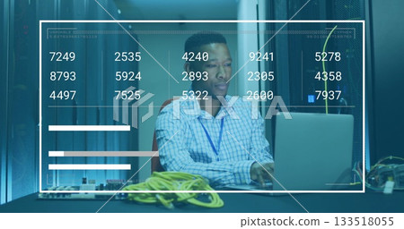 Network engineer checking laptop data in server room, with yellow Ethernet cables and data overlay 133518055