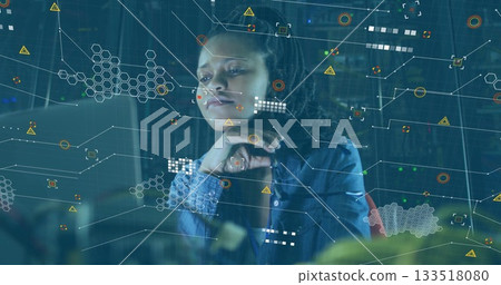 Gazing woman wearing denim shirt examining glowing monitor and data graphics before server racks Gazing woman wearing denim shirt examining glowing monitor and data graphics before server racks 133518080