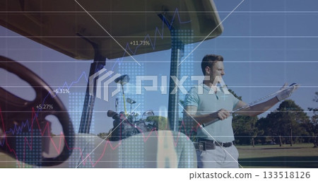 Man in light blue polo inspecting club grip beside golf cart on fairway, with financial graphs 133518126