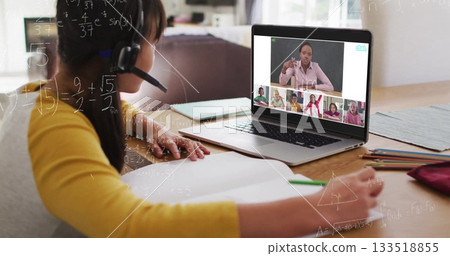 Sitting child wearing yellow top and headset learning virtual math lesson at home desk, copy space Sitting child wearing yellow top and headset learning virtual math lesson at home desk, copy space 133518855