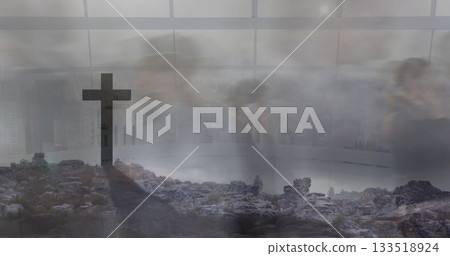 Merging rocky hilltop and blurred colleagues walking corridor, with city skyline behind stone cross 133518924