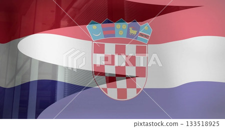 Waving Croatian national flag bearing coat-of-arms fluttering in city, with glass facade reflection 133518925