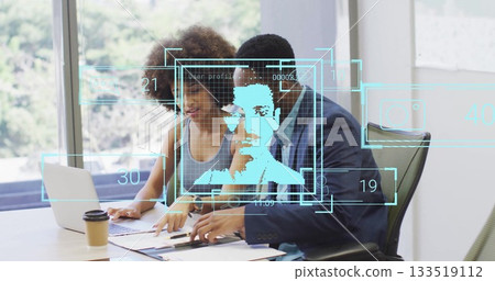 Colleagues analyzing documents and holographic overlays in office meeting room, with laptop 133519112