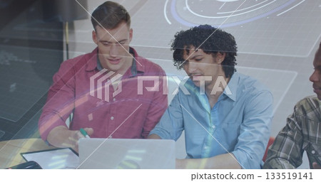 Collaborating coworkers wearing shirts and working on laptop at office table with notebook pen Collaborating coworkers wearing shirts and working on laptop at office table with notebook pen 133519141