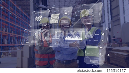 Staff wearing safety helmets and vests using AR dashboards in distribution center aisle 133519157