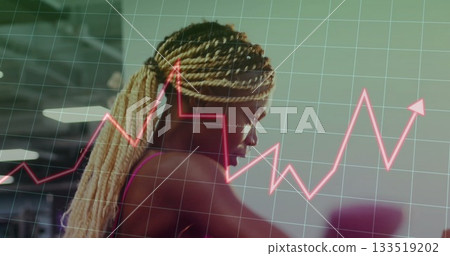 Woman wearing dark sports bra working out in gym, with green grid overlay and pink graph 133519202