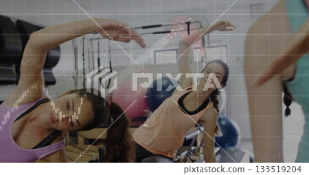 Stretching woman wearing peach tank top, black leggings side bending on reformer at Pilates studio Stretching woman wearing peach tank top, black leggings side bending on reformer at Pilates studio 133519204
