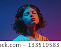 A teenage girl in headphones, with a expressive face and perhaps a few stray hairs flying free, is caught in a peak moment of enjoyment. 133519583