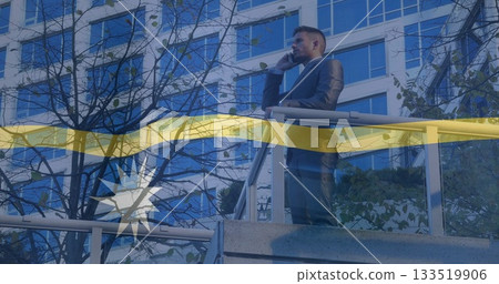 Leaning executive in suit speaking on smartphone at balcony railing with glass windows, copy space Leaning executive in suit speaking on smartphone at balcony railing with glass windows, copy space 133519906
